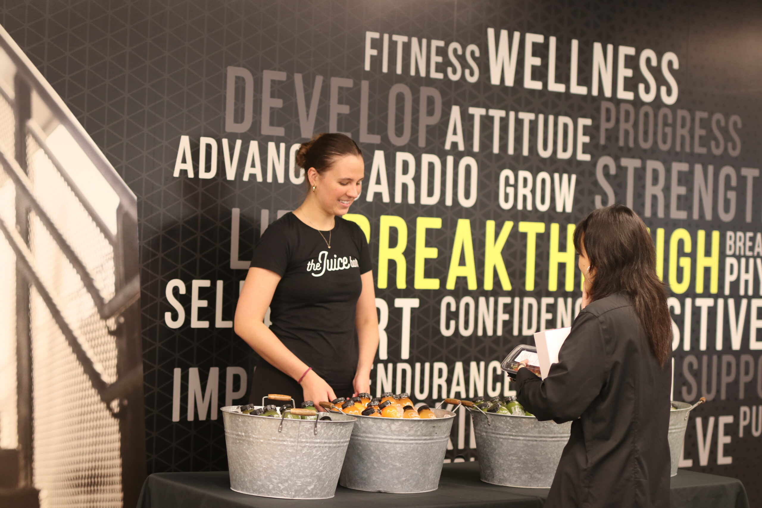 The Juice bar vendor explaining the cold press juices and the health benefits to a tenant at our corporate wellness event