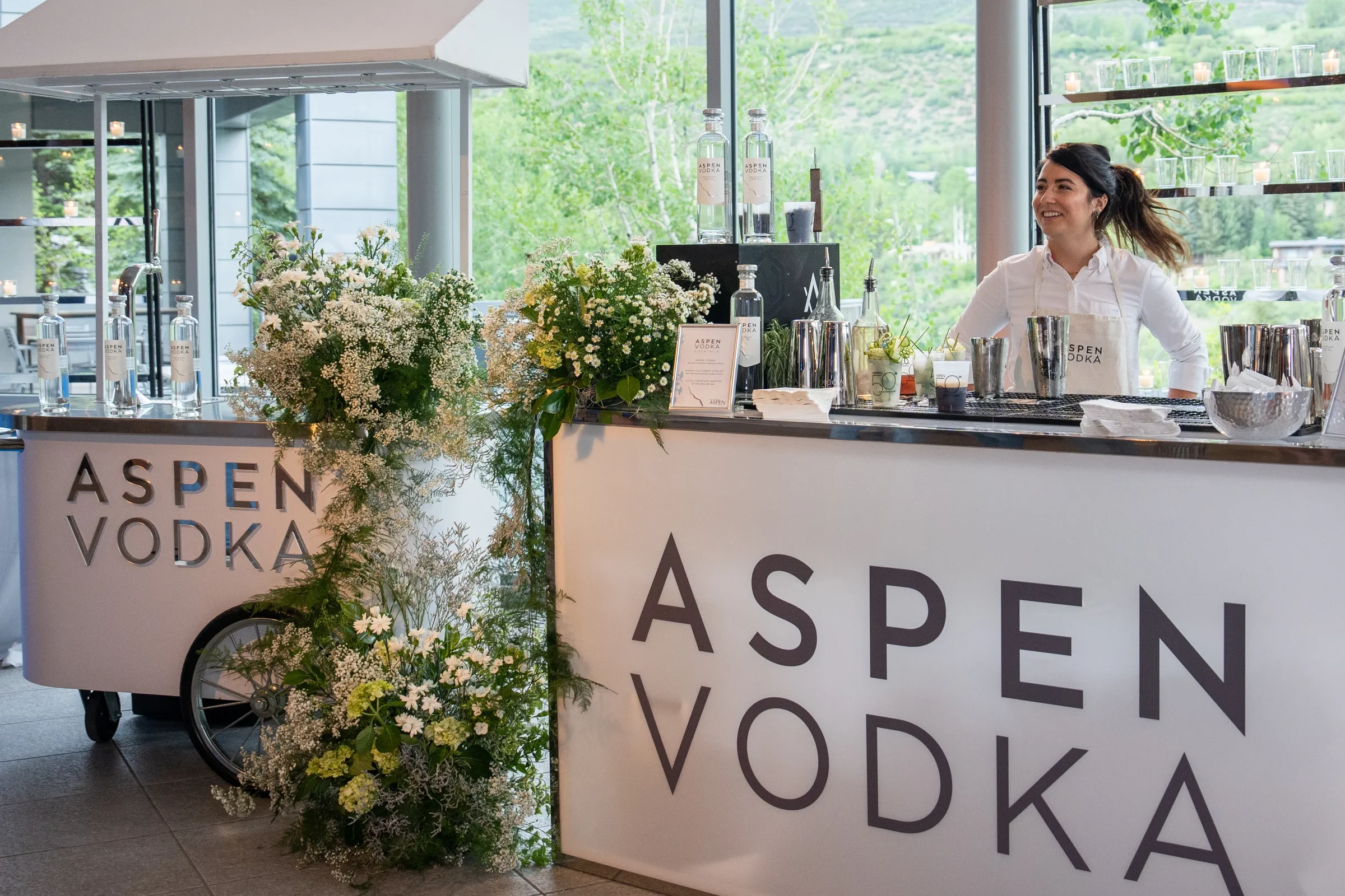 Corporate group sampling Aspen Vodka during a tasting experience, with chilled vodka shots, fresh ingredients, and a clean, modern presentation.